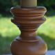 Large wooden lamp with a woven rattan shade.