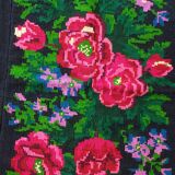 Handwoven floral wool rug, black background with pink roses