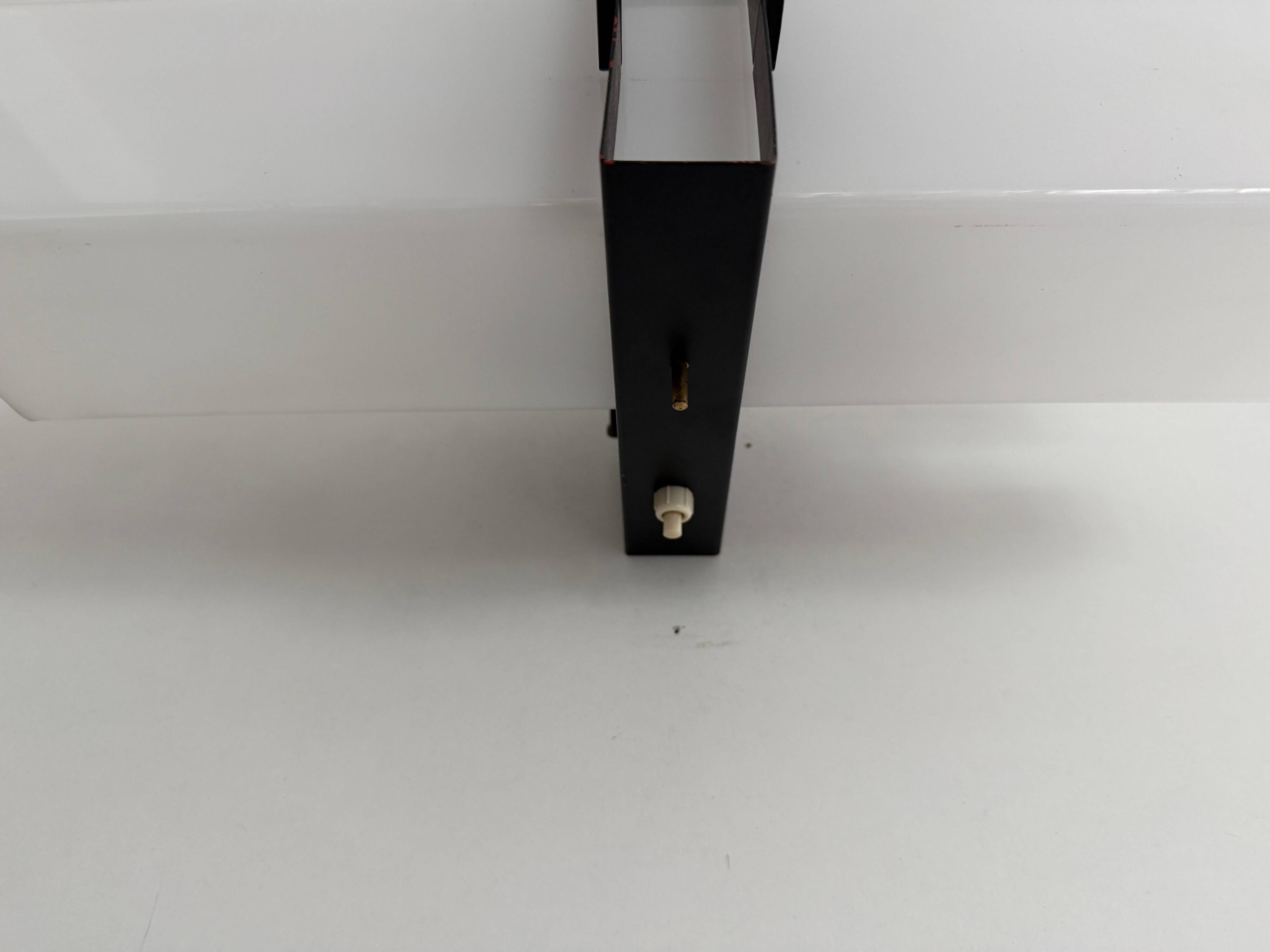 Simple white plexiglass wall light with a black metal frame, 1970s, Germany.