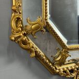 Antique octagonal mirror in richly carved gilded wood, Louis XV style.