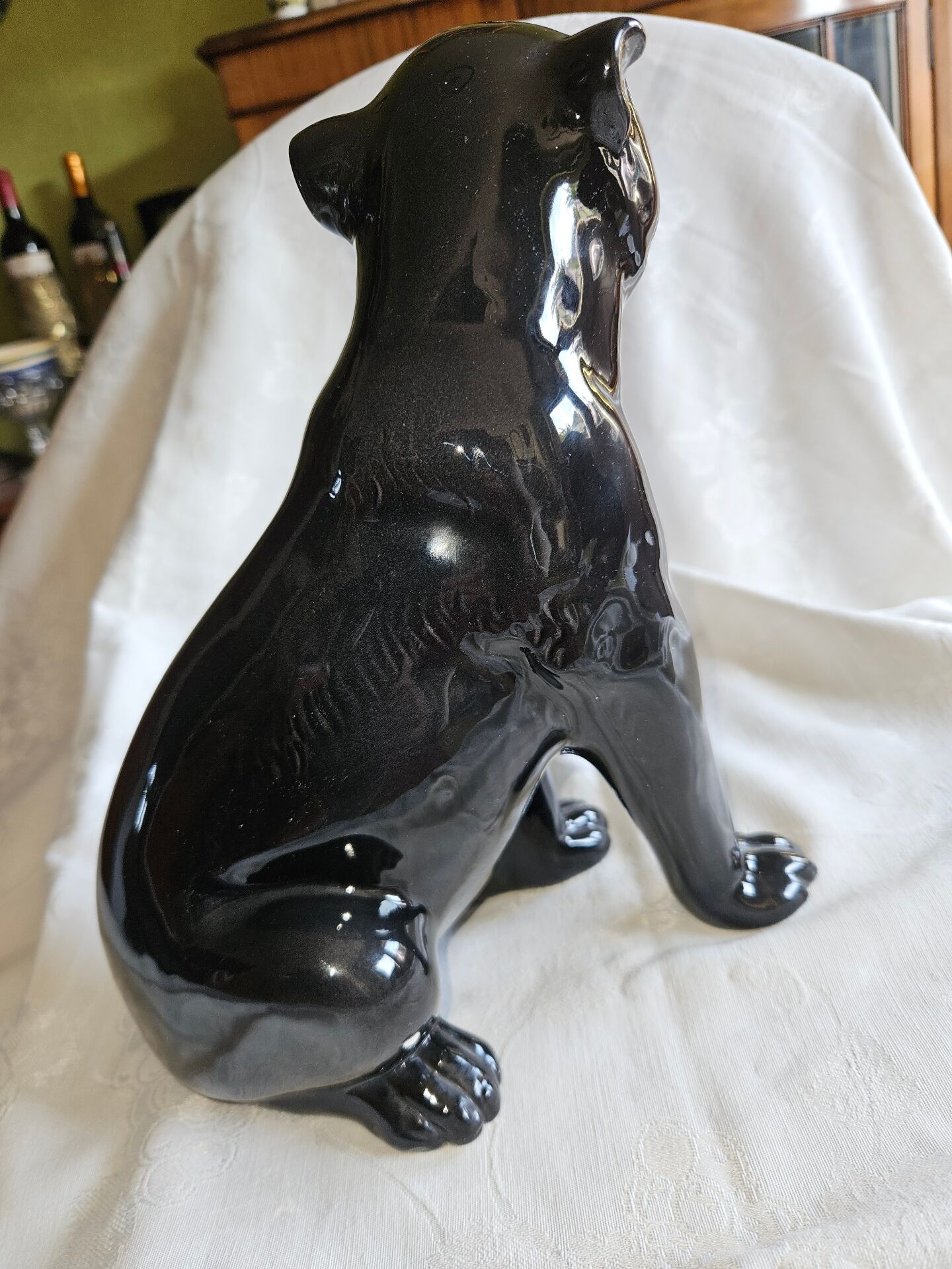 Statue of a roaring panther/leopard sitting in black glazed ceramic.