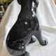 Statue of a roaring panther/leopard sitting in black glazed ceramic.