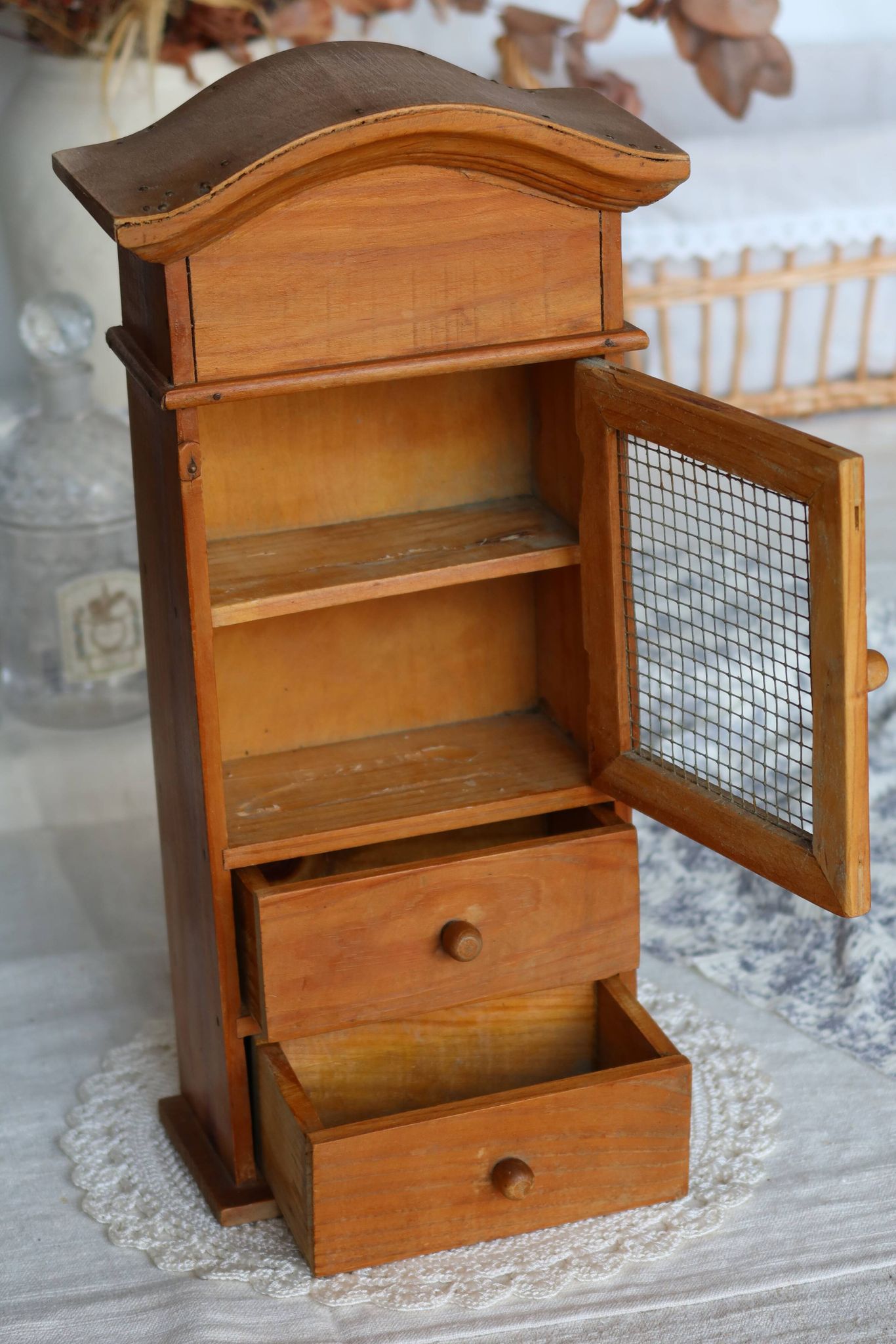 Vintage wooden shelf with drawers and mesh door.