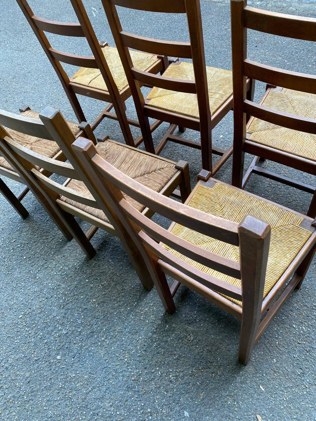 6 light solid wood chairs with high straw backs, farmhouse style.