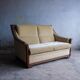 Two-seater Art Deco sofa with ornate wooden details.