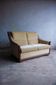 Two-seater Art Deco sofa with ornate wooden details.