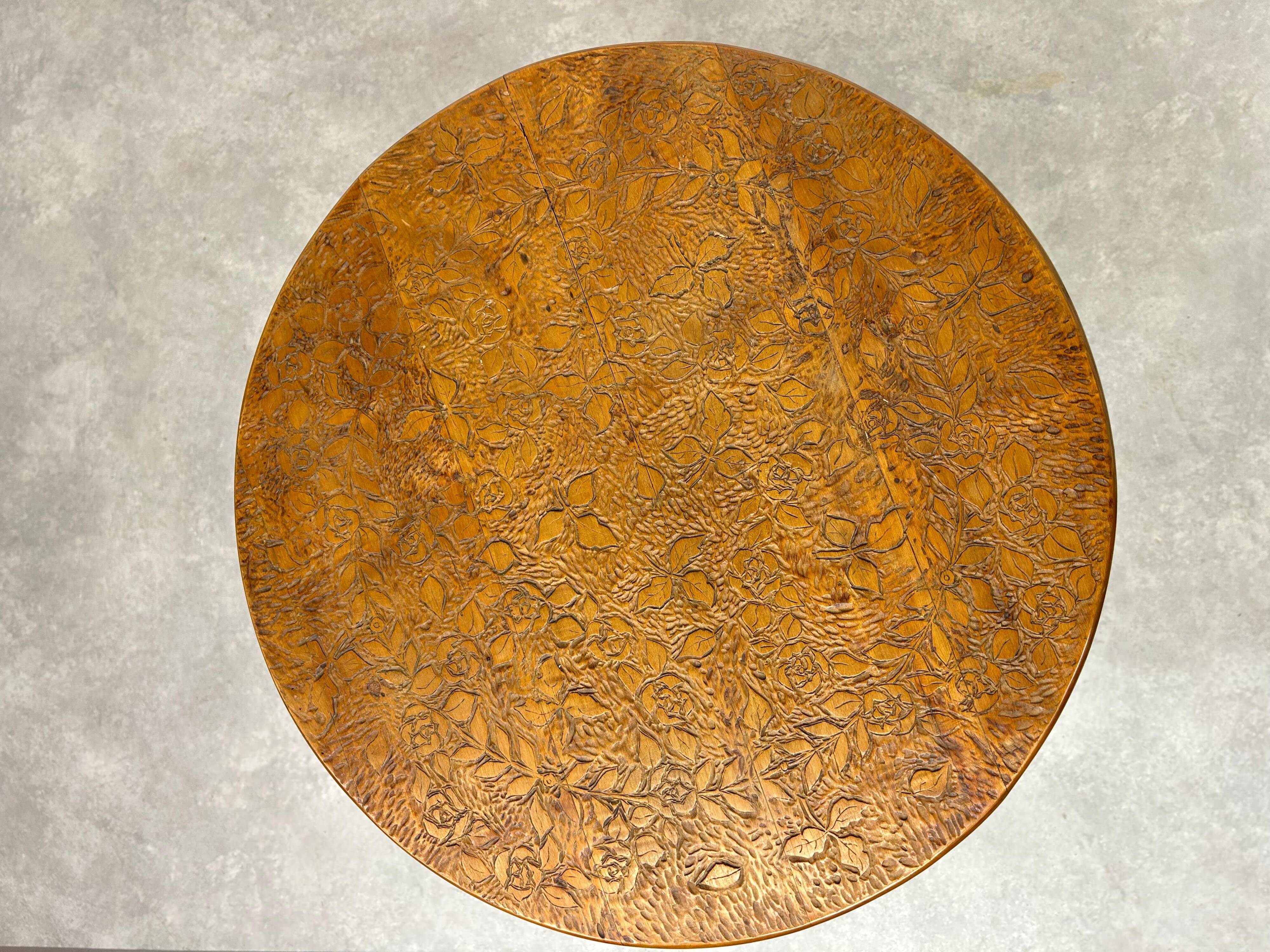 Round Art Nouveau coffee table with a sculpted top.
