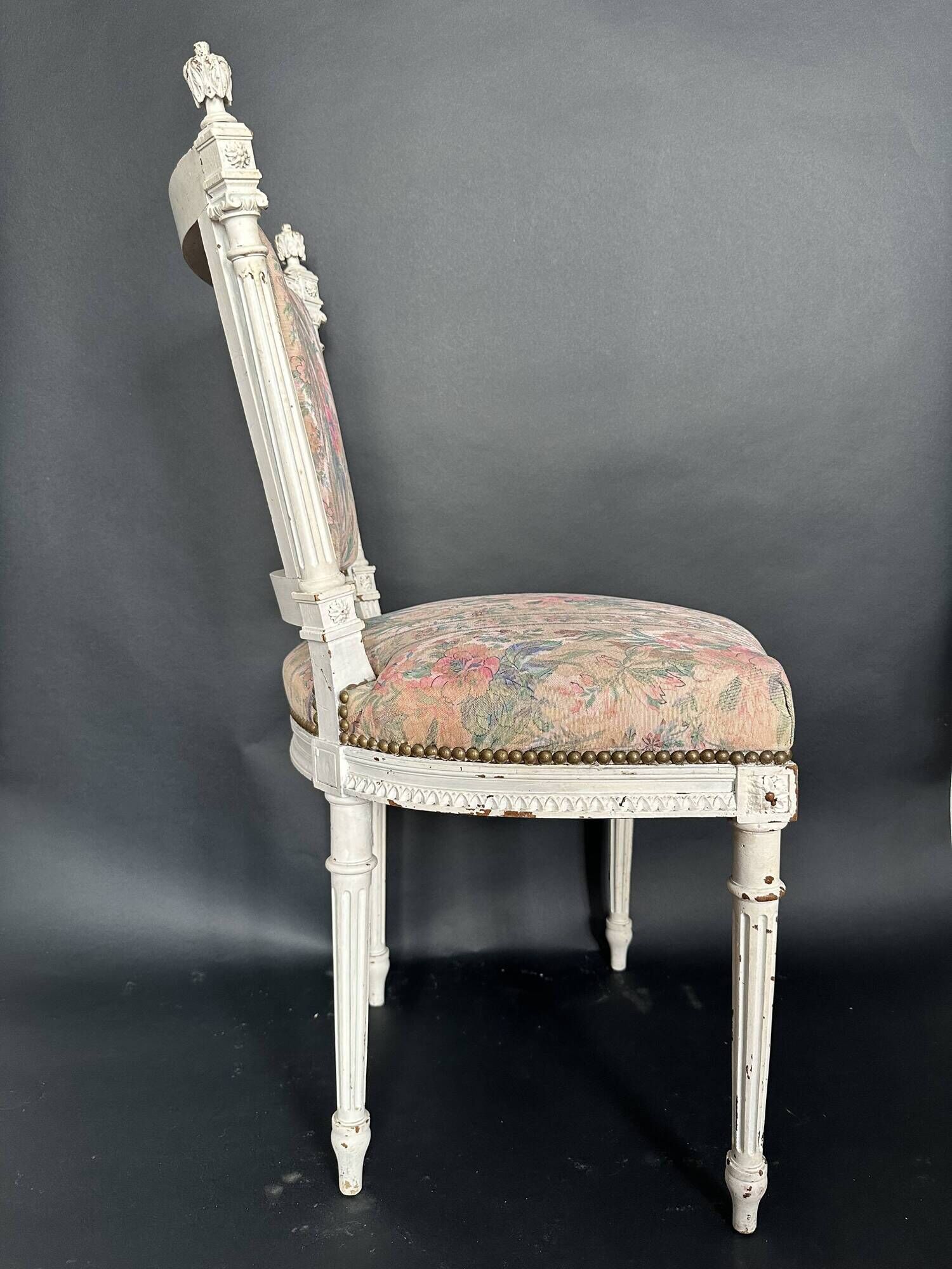 Antique Louis XVI style chair with patinated wood and floral fabric.
