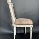 Antique Louis XVI style chair with patinated wood and floral fabric.