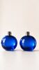 Bright blue glass salt and pepper shakers in a spherical shape.