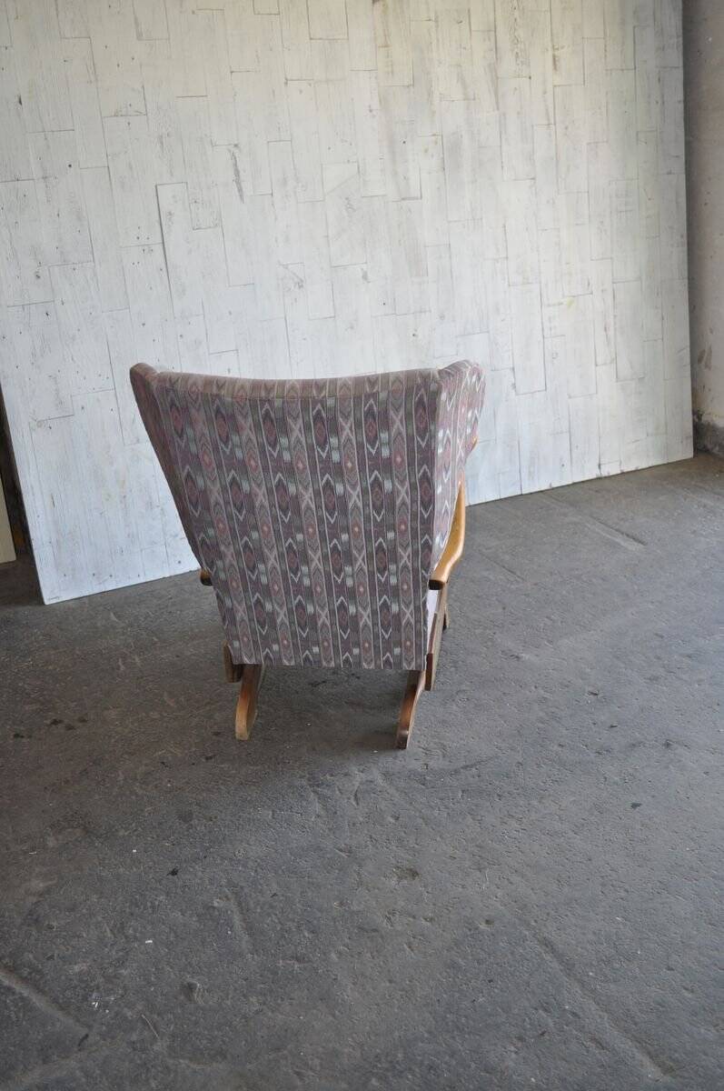 Vintage brown wooden rocking chair from the 1950s, wingback backrest and rocking base.