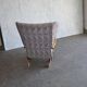 Vintage brown wooden rocking chair from the 1950s, wingback backrest and rocking base.