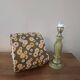Table lamp with light green onyx base, fabric shade with a khaki background.