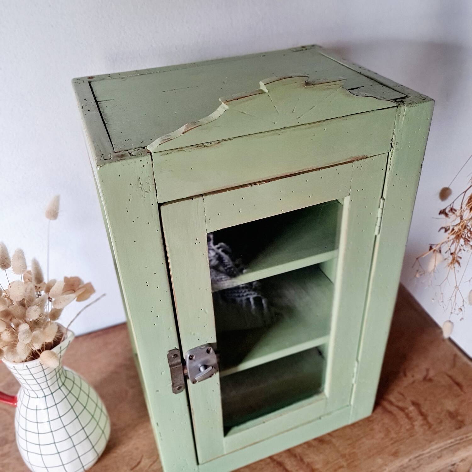 Small glass cabinet in green colour.