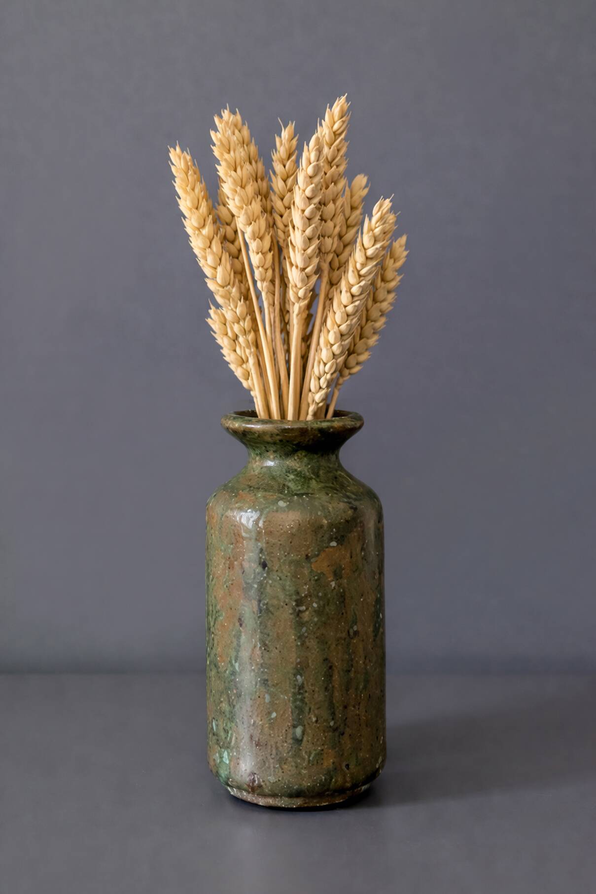 Wabi-sabi artisanal stoneware vase in green and earth tones.