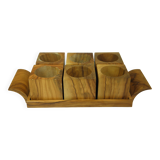 Six egg cups on a wooden tray.