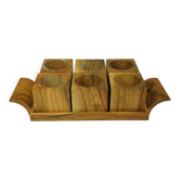 Six egg cups on a wooden tray.