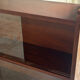 Vintage 1960s wooden library with sliding doors.