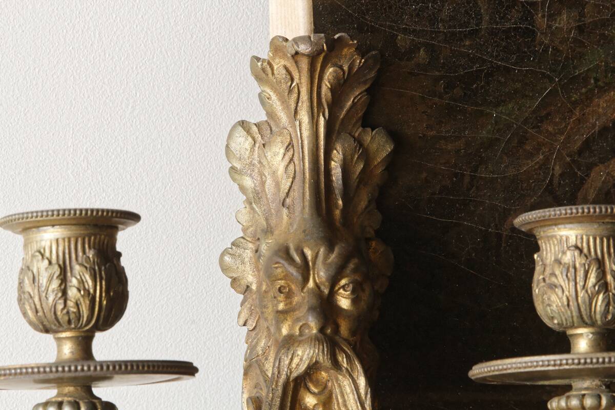 Monobloc gilded bronze wall light, grotesque satyr, two lights.