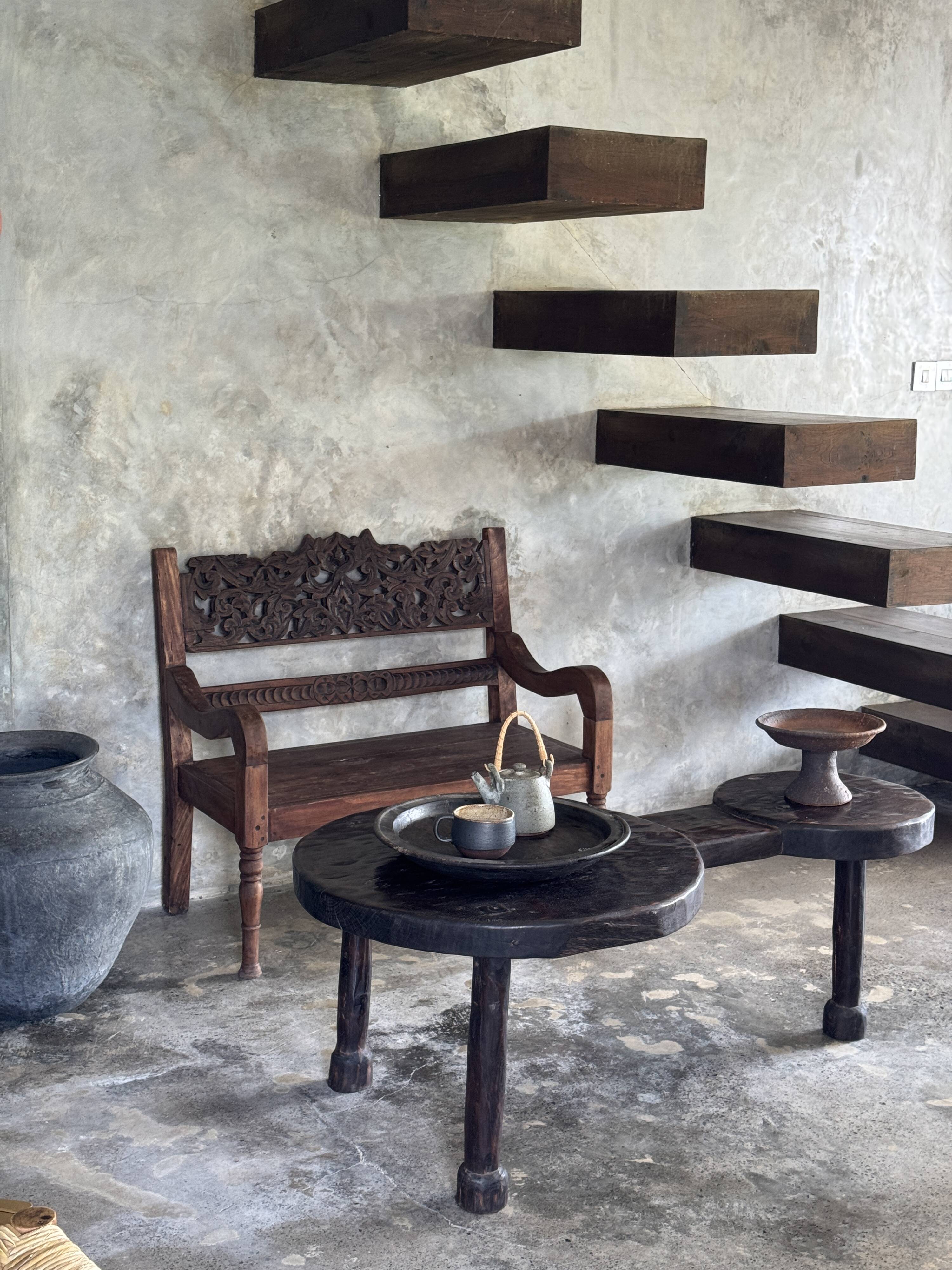 Small antique Indonesian bench in carved teak with plant and floral motifs.