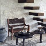 Small antique Indonesian bench in carved teak with plant and floral motifs.