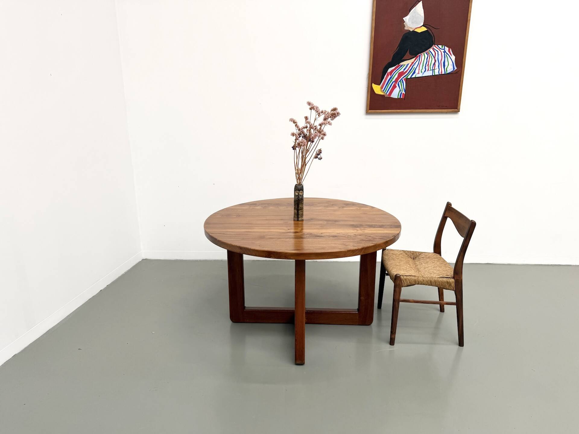 Modernist round table in solid elm, crossed legs.