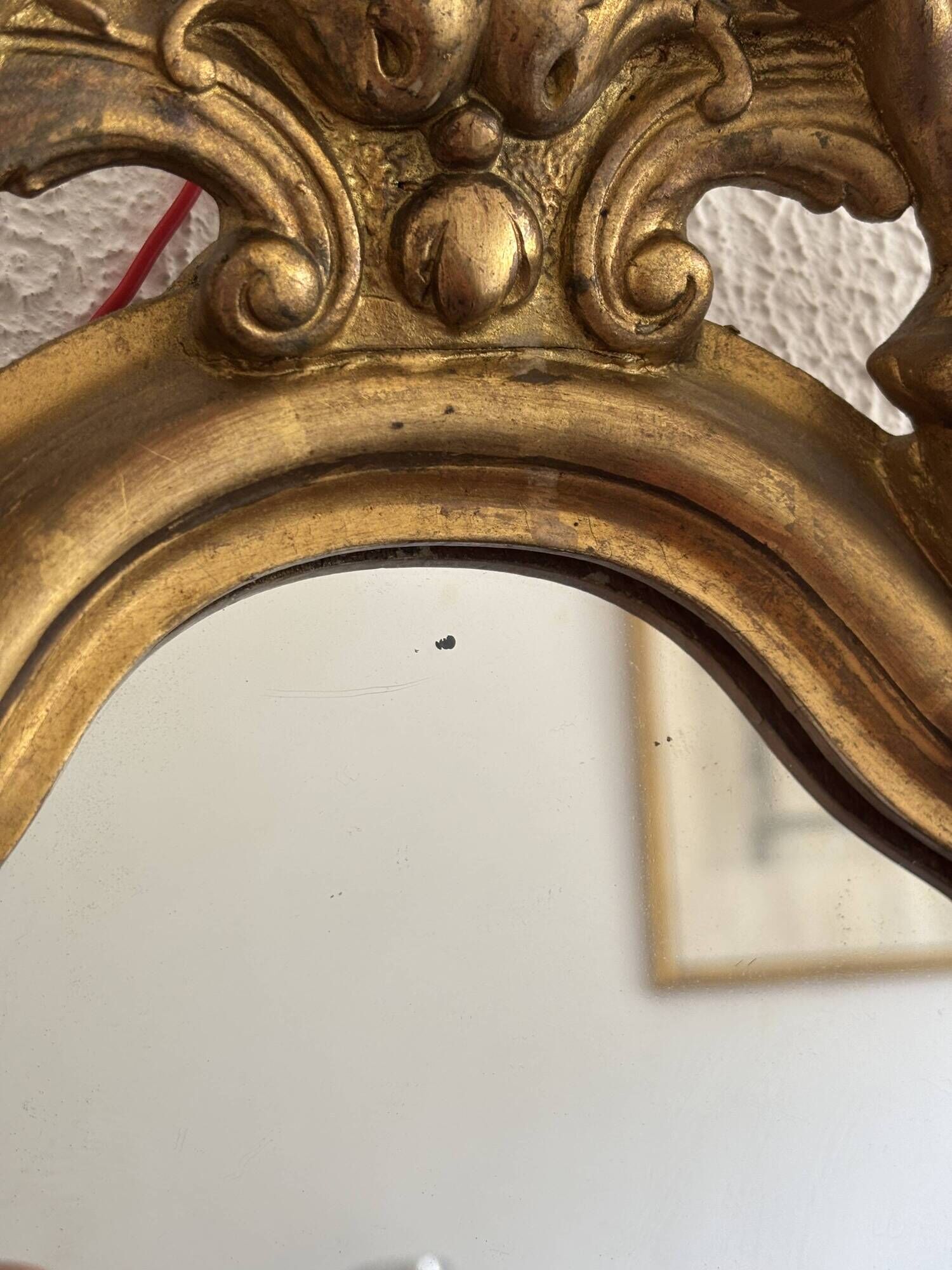 Antique rococo mirror with putti, gilded carved wood and stucco frame, 19th century.