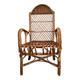 Child's rattan armchair with a high backrest.
