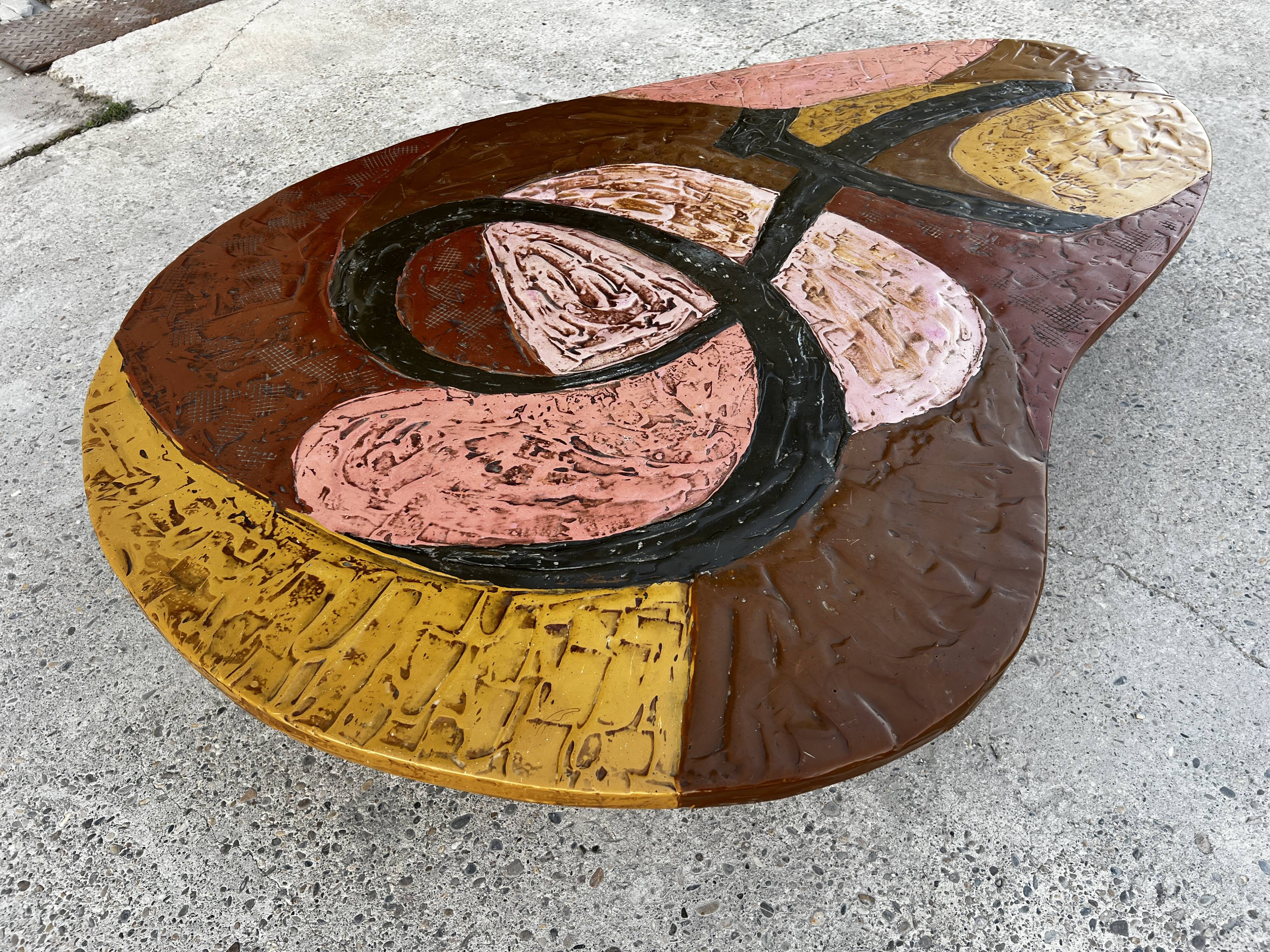 Table basse en résine scarifiée, pieds gainés de cuir marron signé 1960