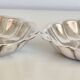 Silver-plated shell-shaped butter dishes, in the shape of a scallop shell.