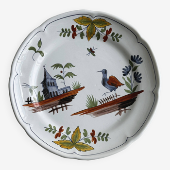 Assiette en faïence peinte à la main avec décor de paysage et oiseau.