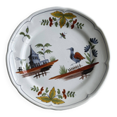 Hand-painted earthenware plate with landscape and bird decoration.