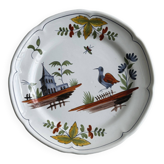 Hand-painted earthenware plate with landscape and bird decoration.