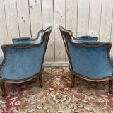 Paire de fauteuils bergères de style Louis XV en velours bleu et bois doré