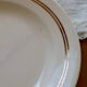 Round vintage ivory earthenware serving dish with double gold trim.