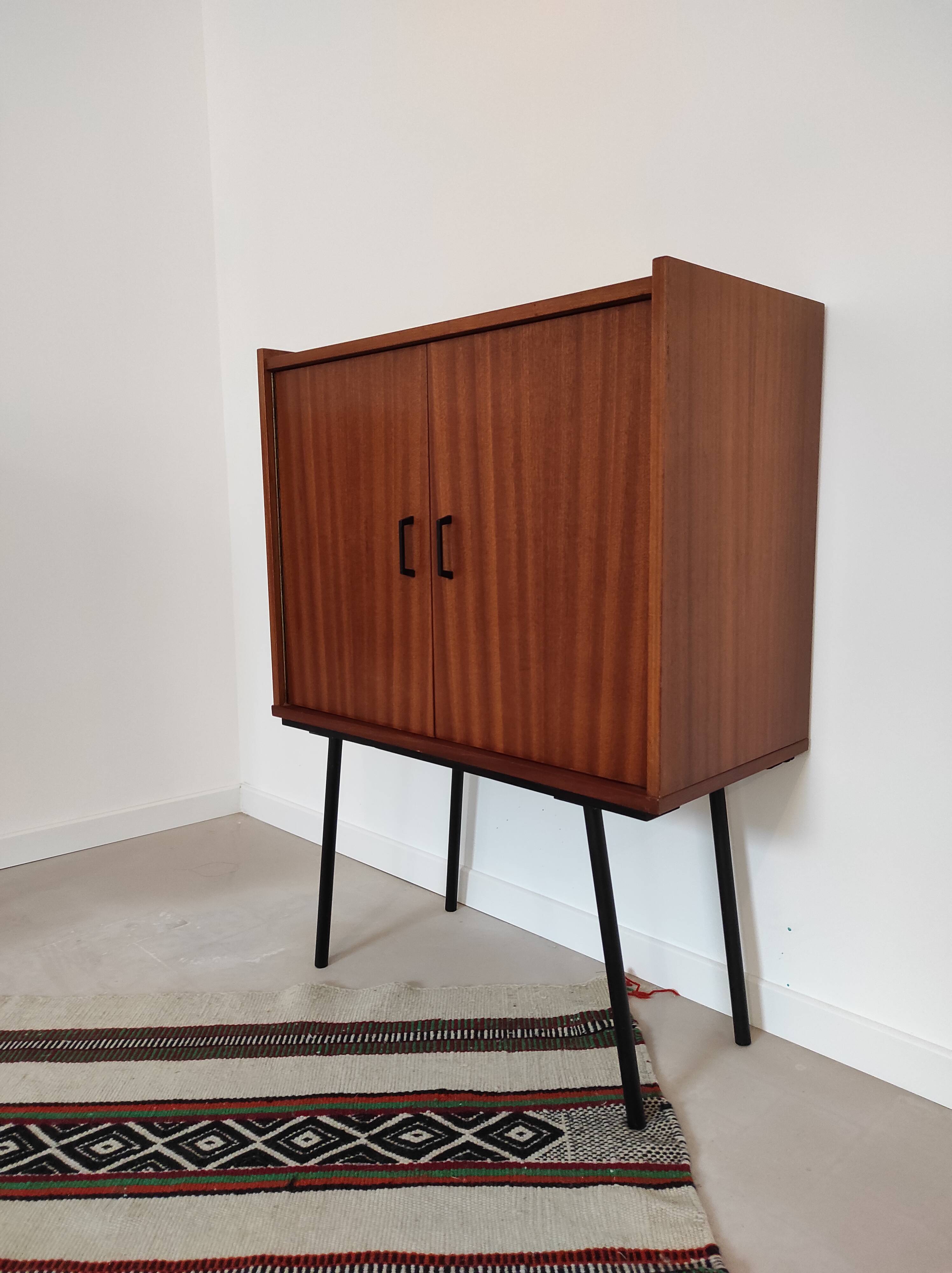 Piece of furniture on high feet metal compass