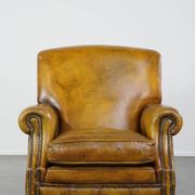 Comfortable large yellow English-style leather armchair with a fine finish and decorative nails