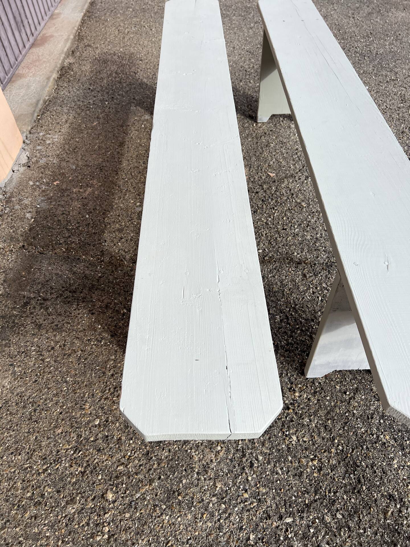 Pair of wooden benches painted white, French artisanal work.