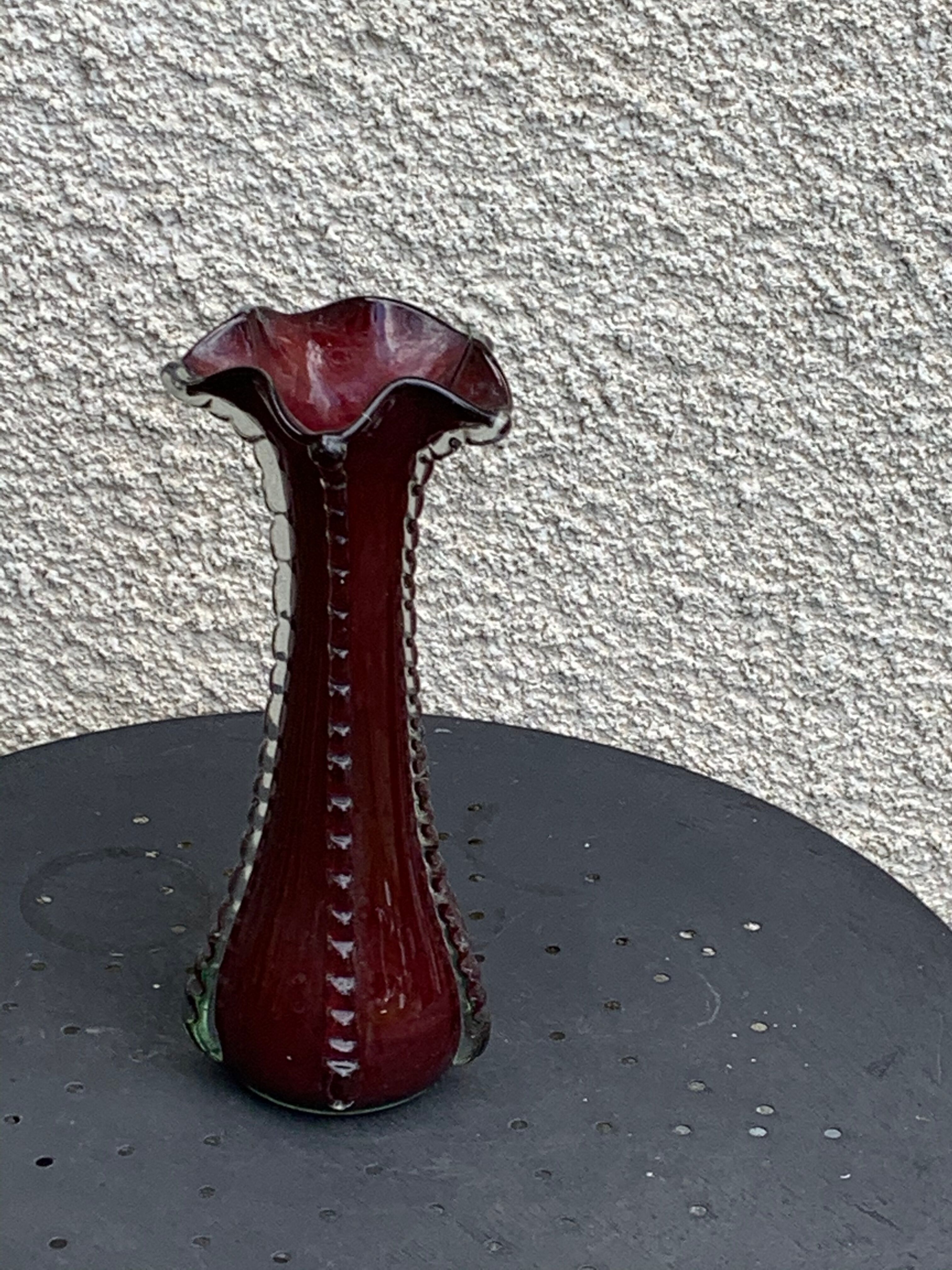 Burgundy red blown glass vase in the shape of a vintage corolla