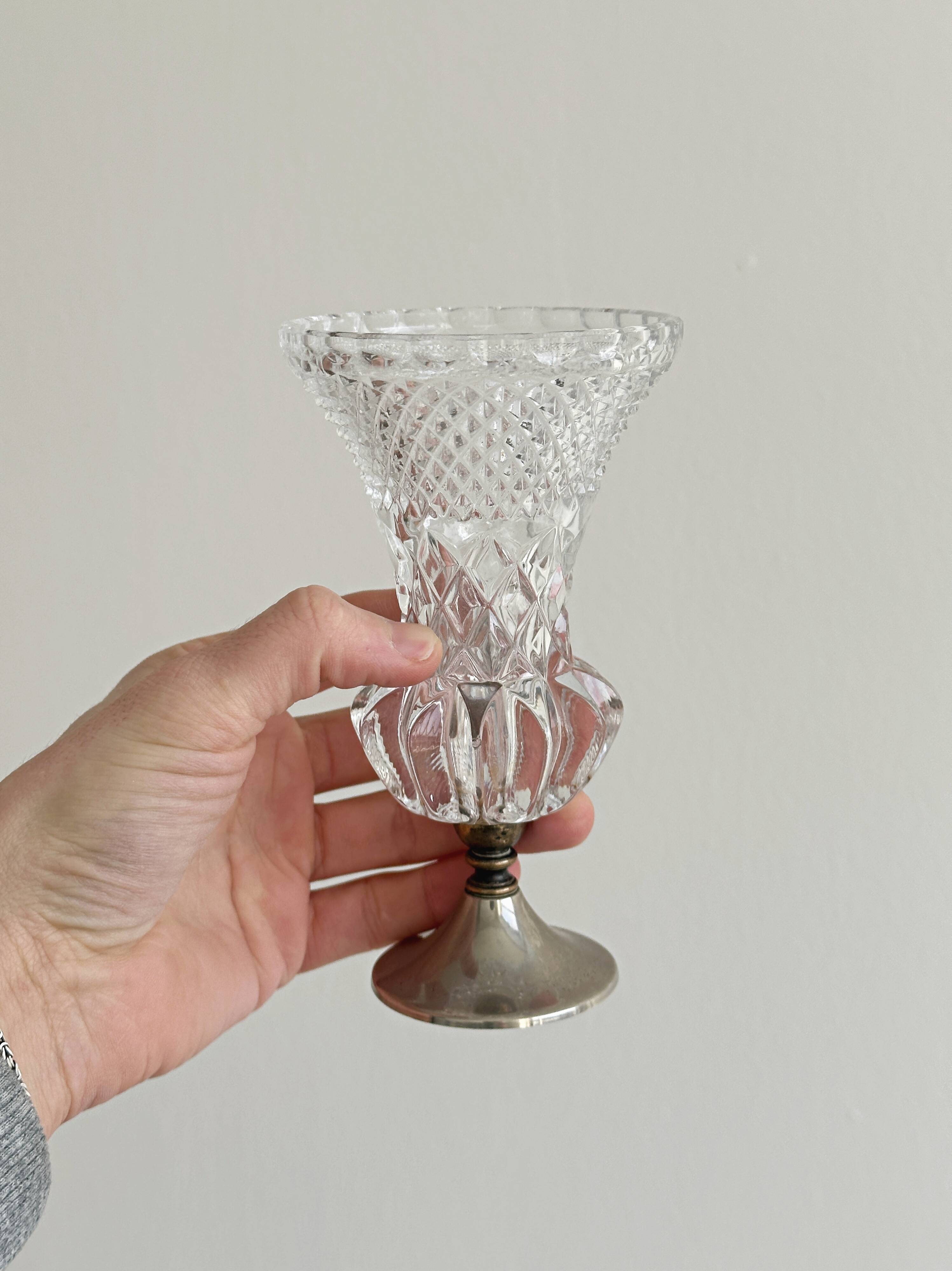 Small vase on a metal stand with thick glass.