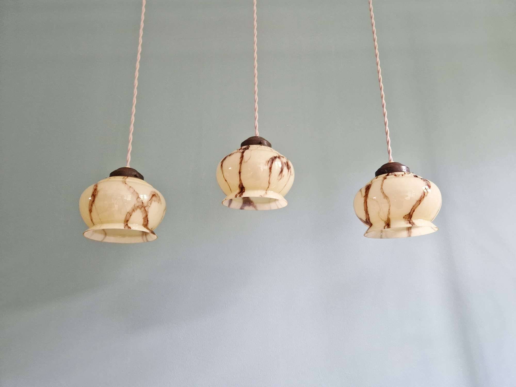 Trio of Art Deco marbled opaline pendant lights, 1920-30