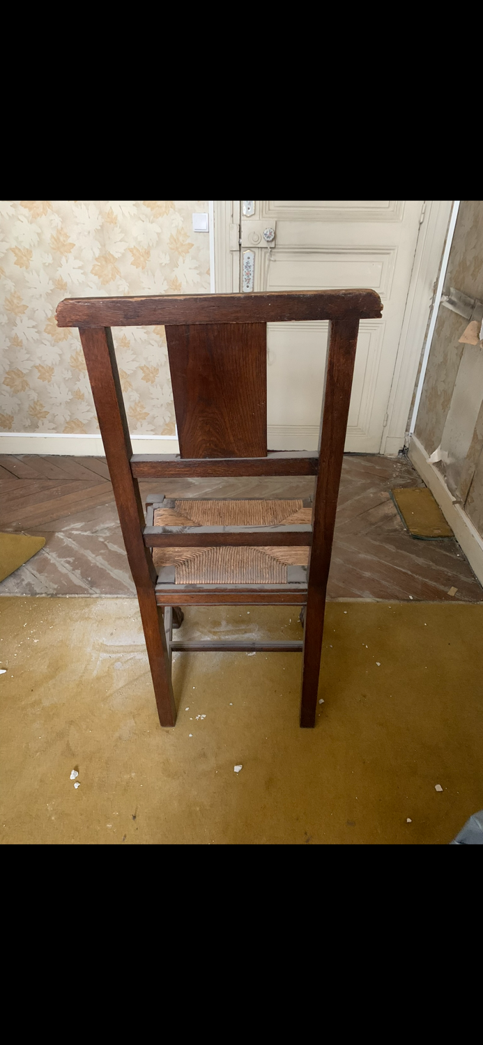 Antique carved wooden chairs with straw seats.