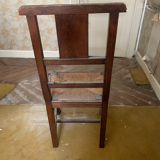 Antique carved wooden chairs with straw seats.