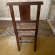 Antique carved wooden chairs with straw seats.