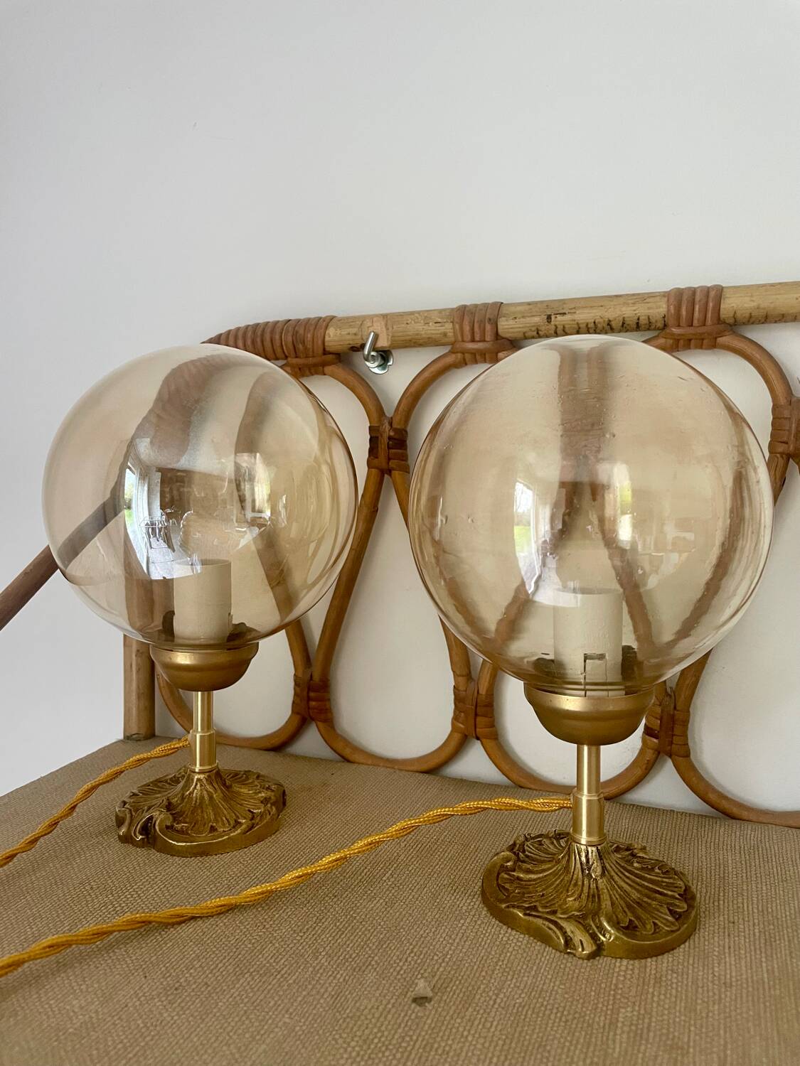 2 bedside lamps with round amber glass globes and gold metal.