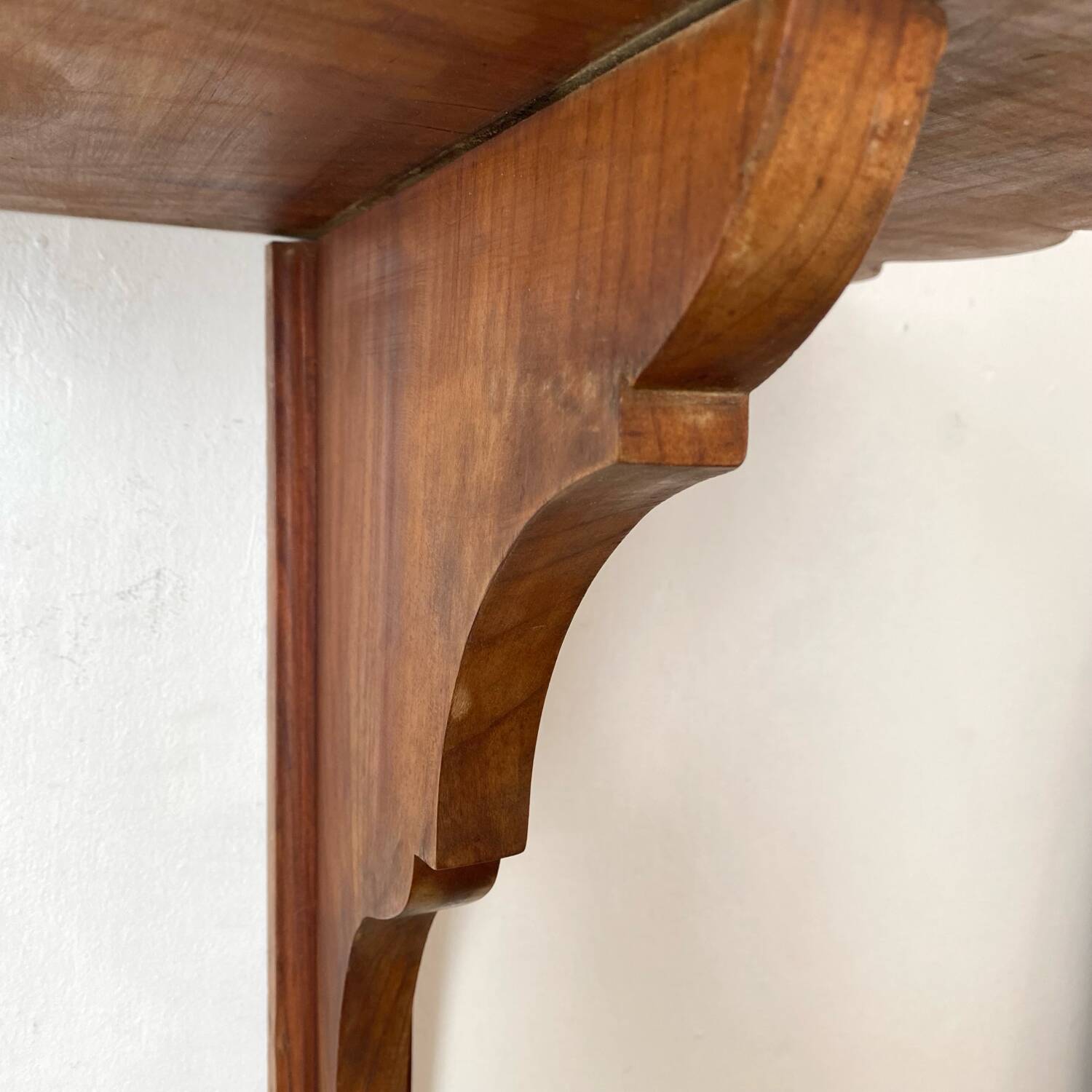 Antique wall shelf with a scalloped edge.