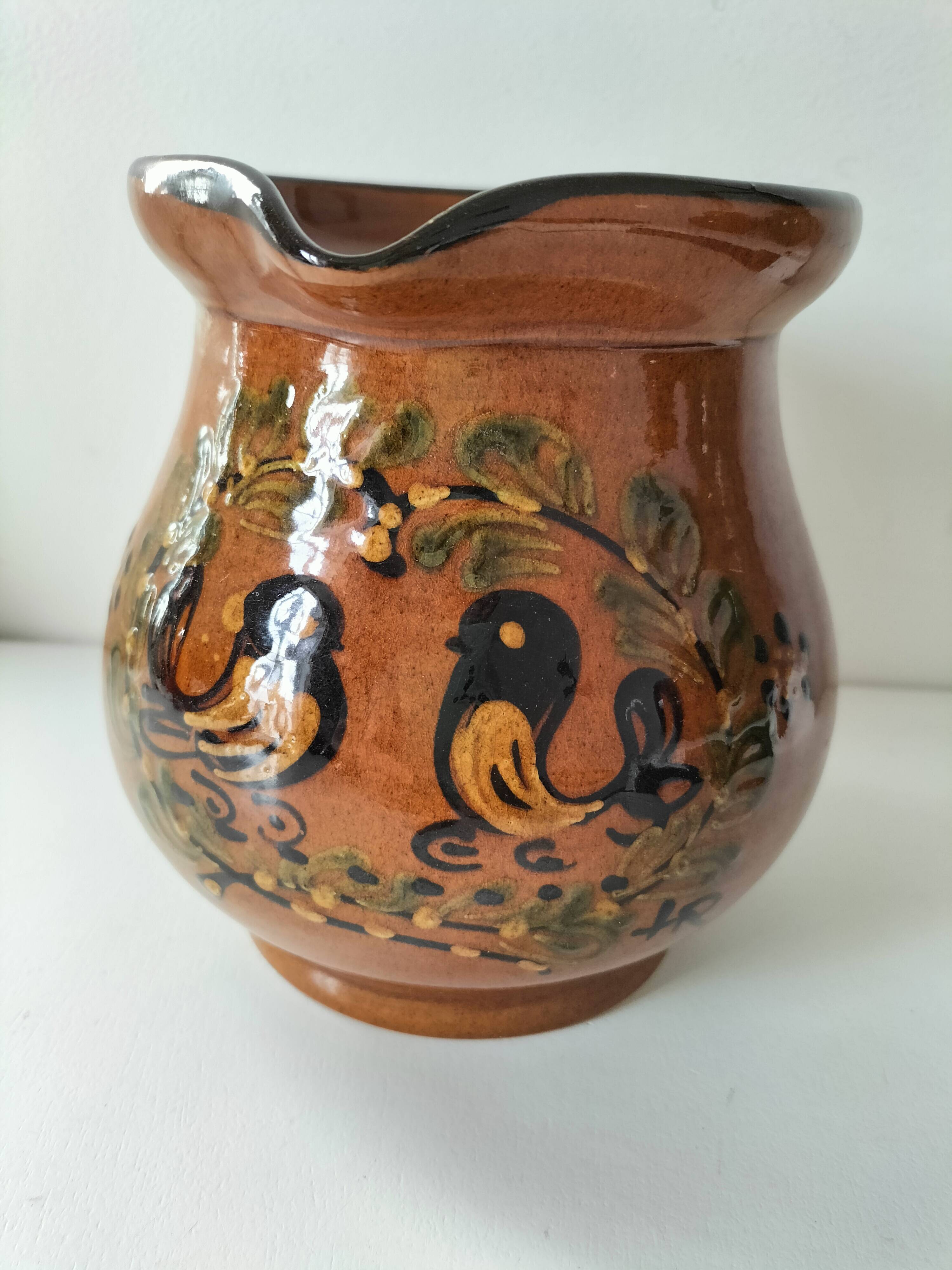 Glazed earthenware pitcher signed HR with a design of stylised birds.