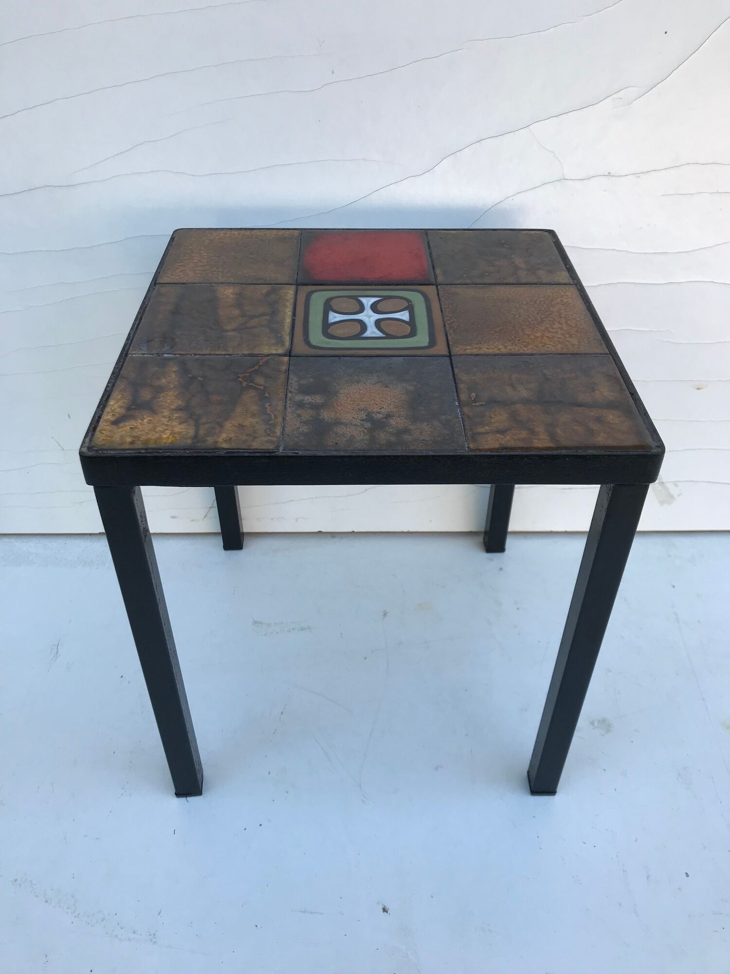 Old black metal and majolica tiles table