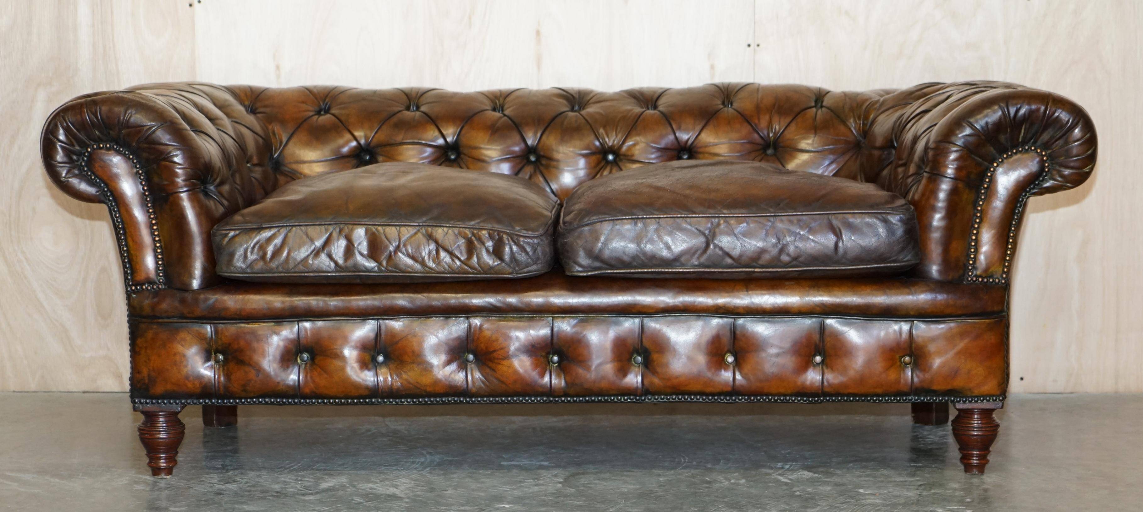 Victorian Chesterfield leather upholstered canapé with feather cushions.