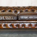 Victorian Chesterfield leather upholstered canapé with feather cushions.